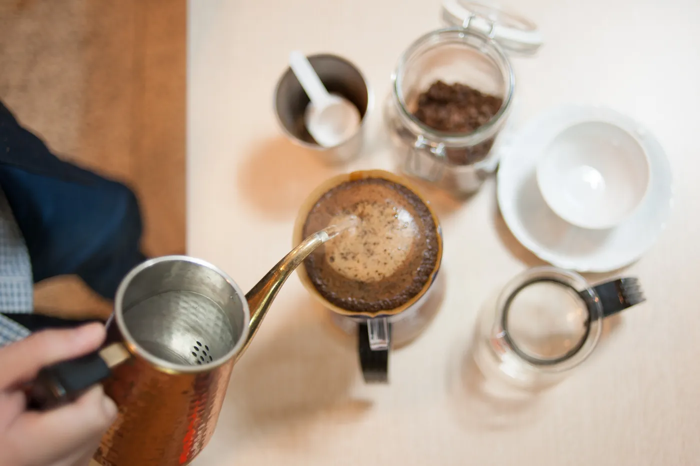 Manual pour-over drip coffee brewing into a cup on a kitchen counter