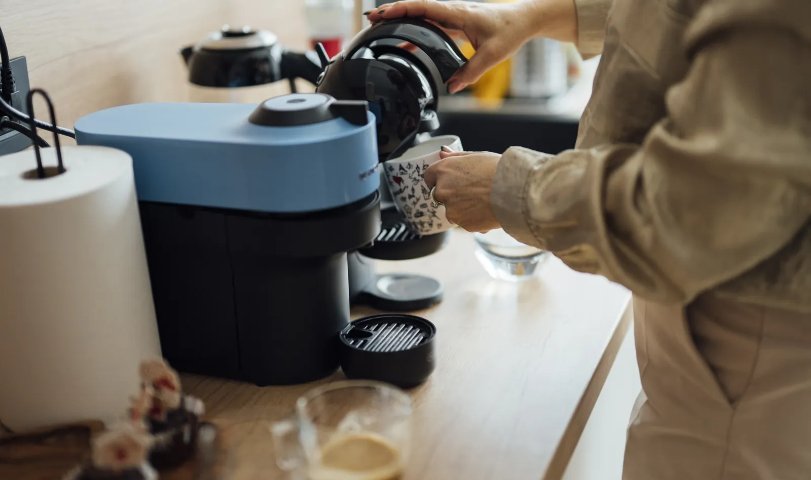 Bright home kitchen counter with a coffee machine, cup, and morning brewing setup